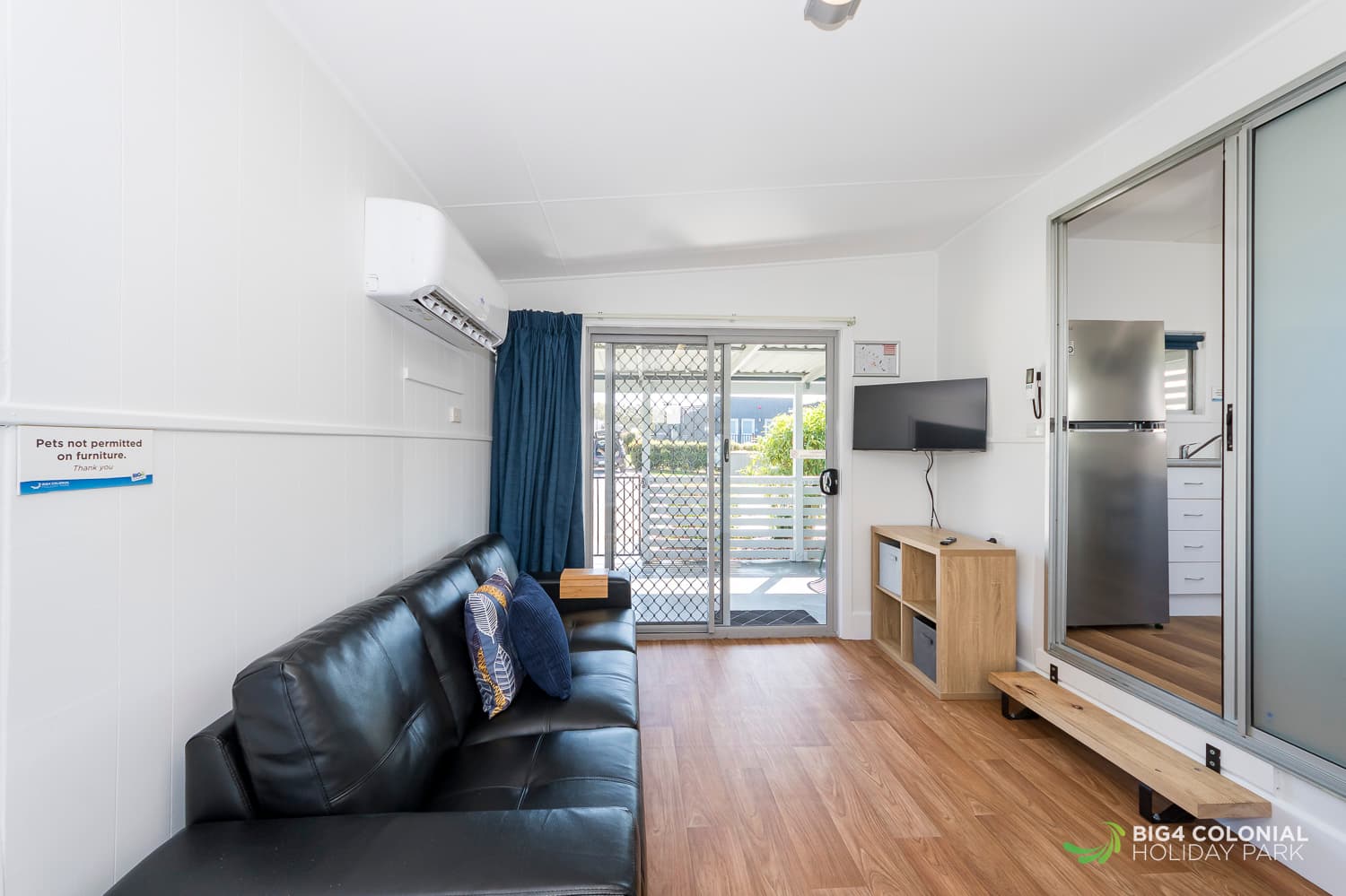 Four seater couch in spacious living area of the two room studios. 