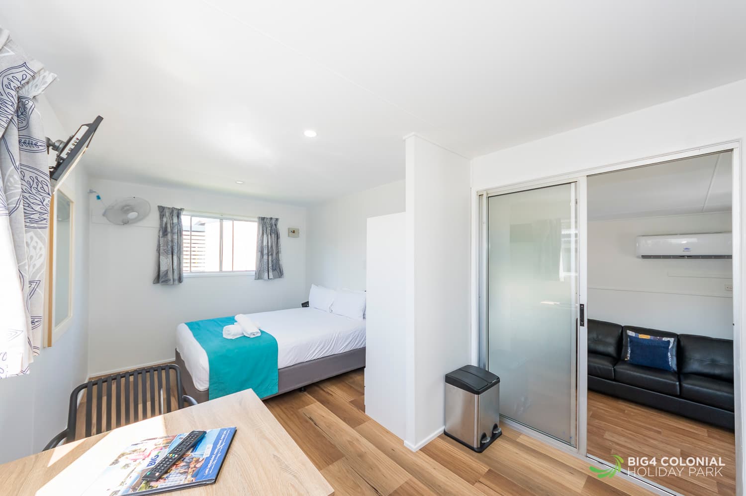 Queen bed and two seater dining table in two room studio. 